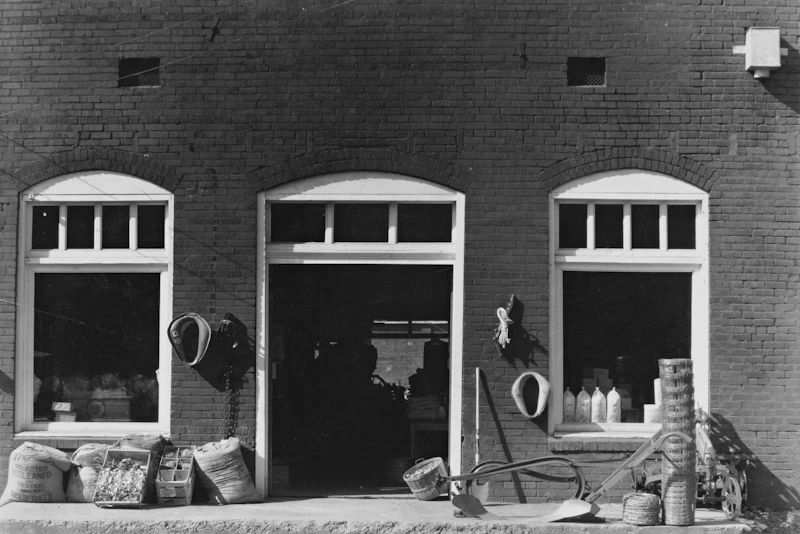Warehouse entrance with agricultural sacks and equipment outside