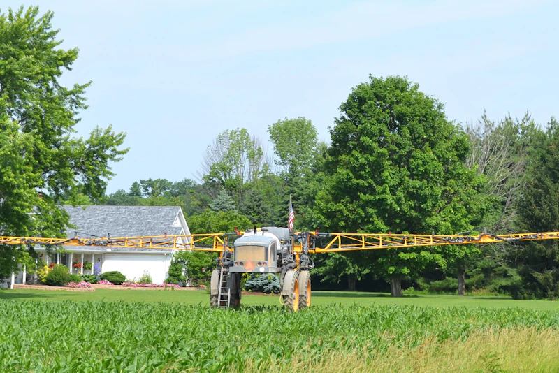 Tractor spraying crops across an agricultural field