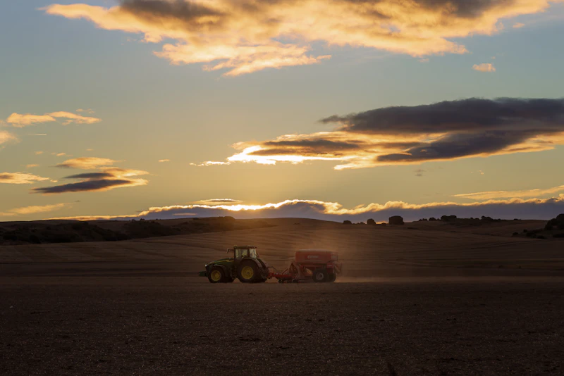 Tractor plowing a field at sunset